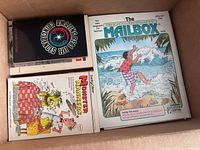 Box with assorted vintage children's books visible including 'Monster Manners' and 'The Mailbox' magazine.