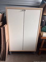 Full view of Ikea cabinet showing front with double doors and metal knobs