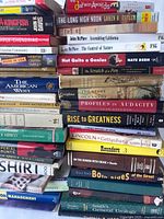 Stack of non-fiction books including titles on history, science, politics, and management.