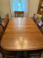 Top view of rectangular wooden dining table with six chairs around it.