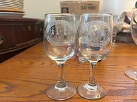 Two clear glasses etched with Maryland Wine Festival logo and grapevine design on their bowls.