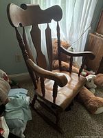 Front angled view of wooden rocking chair showing backrest and armrest details