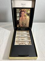 Full display case with four pairs of Monet eyeglass frames in original box with vintage advertisement.