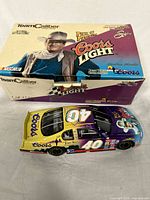 Photo showing the diecast car and original box with John Wayne and Coors Light graphics