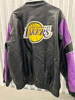 Back view of the men's XL Los Angeles Lakers black leather jacket with purple accents and large embroidered team logo.