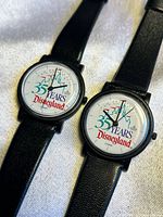 Close-up photo of two black Disneyland 35th anniversary watches showing face design and black straps.