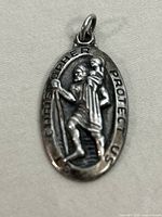 Front view of oval 925 silver Saint Christopher pendant, showing detailed raised image and inscription