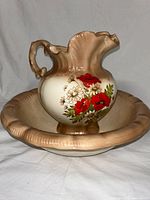 Front angle showing basin and pitcher with floral handpainted design and scalloped shapes.