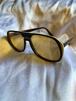 Front angled view showing the tinted amber lenses and black frame with silver temples.