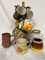 Photo of 10 vintage coffee or tea mugs arranged on a wooden mug rack with some mugs standing in front