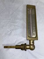 Full view of the brass thermometer body with glass tube and brass fitting on a white background.