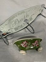 Mirrored wall mount bath hook showing three metal hooks and etched bath themed mirror