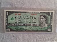 Front side of the 1967 Canadian Centennial One Dollar Banknote showing portrait of Queen Elizabeth II, bilingual text, and signatures.