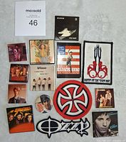 Top-down photo showing entire 14 item lot on white cloth background including paper buttons and two cloth patches