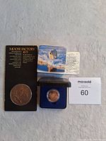 Full lot displaying Moose Factory commemorative coin on card and Polar Bear twoonie in protective case inside black presentation box with maxsold auction number card.