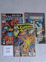 Three comic books laid side by side showing covers: The New Warriors, Superman The Man of Steel, DeadlyStrike The Terminator