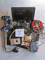 Full lot overview showing all included electronic devices and accessories including camera, controller, CD player, microphone, and cables.