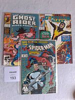 Three Marvel comic books shown: Ghost Rider Rides Again #3, Guardians of the Galaxy issue, and Spider-Man guest-starring The Punisher issue #32. All are in clear protective sleeves placed on a white surface.