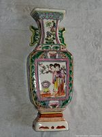 Full view of the vintage Chinese porcelain wall pocket vase showing overall shape, multicolored hand-painted decorations, and floral and figure scenes on the front.