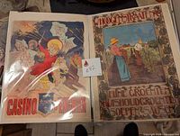 Photo of two vintage unframed prints Casino and Whoogen Straten placed side by side on a dark surface.