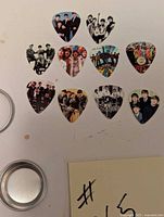 10 different guitar picks with Beatles images arranged in two rows, showcasing various band photos and artwork.