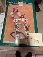 Box showing Traditions brand Skiing Snowman Candle Holder with colorful snowman decorations and holiday theme.