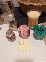 Photo showing the large cream-colored candle in glass, Glade Strawberries & Cream candle, Yankee Candle diffuser refill, and a festive Glade candle.