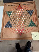 Full view of the vintage Chinese checkers board showing star pattern and painted colored triangles on the game surface, wooden frame around the board edges.