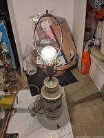 Full view of ceramic lamp base showing height and lamp fixture with bulb lit