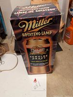 Photo of the Miller Genuine Draft rotating lamp packaging box showing branding and product details.