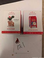 Photo showing both Hallmark Keepsake ornament boxes side by side, Winter Wonder Marigold's Garden on left and Letters for Santa on right.