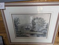 Front view of the framed print showing a rural landscape scene with trees and house, titled and numbered.