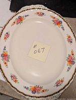 Full view of the oval floral platter showing the floral pattern and black and gold trim.