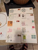 Overall view of 10 first day of issue stamped covers arranged on a table.