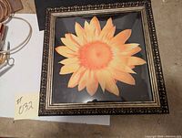 Full view of square framed picture with a bright sunflower on a black background.