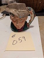 Front view of the Royal Doulton Toby Mug "The Poacher" showing facial features and hat detail