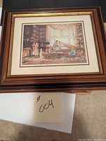 Framed print of Christmas family scene by Trish Romance on table