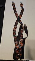 Full view of Harley Davidson suspenders showing logo pattern and metal clips.