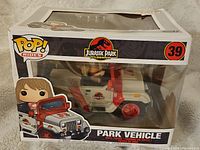 Front view of boxed Funko Pop Rides Jurassic Park 25th Anniversary park vehicle with character figure inside clear window box showing branding and product information.