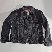 Front view of black Levis denim jacket laid flat showing general condition and style.