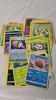 Photo of assorted Pokemon cards spread out showing various character and trainer cards.