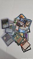 Pile of approximately 40 assorted Magic: The Gathering cards in various colors and card types, some sleeves visible.