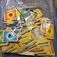 Pile of assorted Pokémon Energy cards in plastic bag showing multiple elements including Water, Fire, Electric.