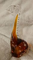 Side view of amber and clear glass giraffe figurine showing detail of neck and body