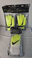 Three pairs of new Nike GK Match youth size 7 goalkeeper gloves in original packaging, showing front view with neon yellow color and black Nike swoosh.