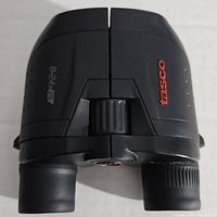 Top view of Tasco binoculars showing the focusing wheel and branding, with 8-24x25 magnification marking.