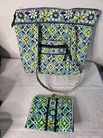 Full view of Vera Bradley purse with matching photo wallet placed in front, showing floral geometric pattern and purse handles