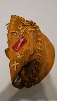 Front view of the vintage Louisville Slugger catchers mitt showing the red brand patch and leather stitching detail.