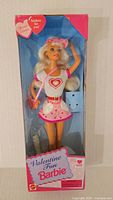 Front view of Vintage Valentine Fun Barbie doll in original packaging showing the doll in white top with red heart, pink skirt with hearts, and accessories including pink purse and visor.