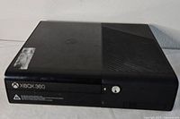 Front overview showing Xbox 360 console with disc tray and some surface wear.